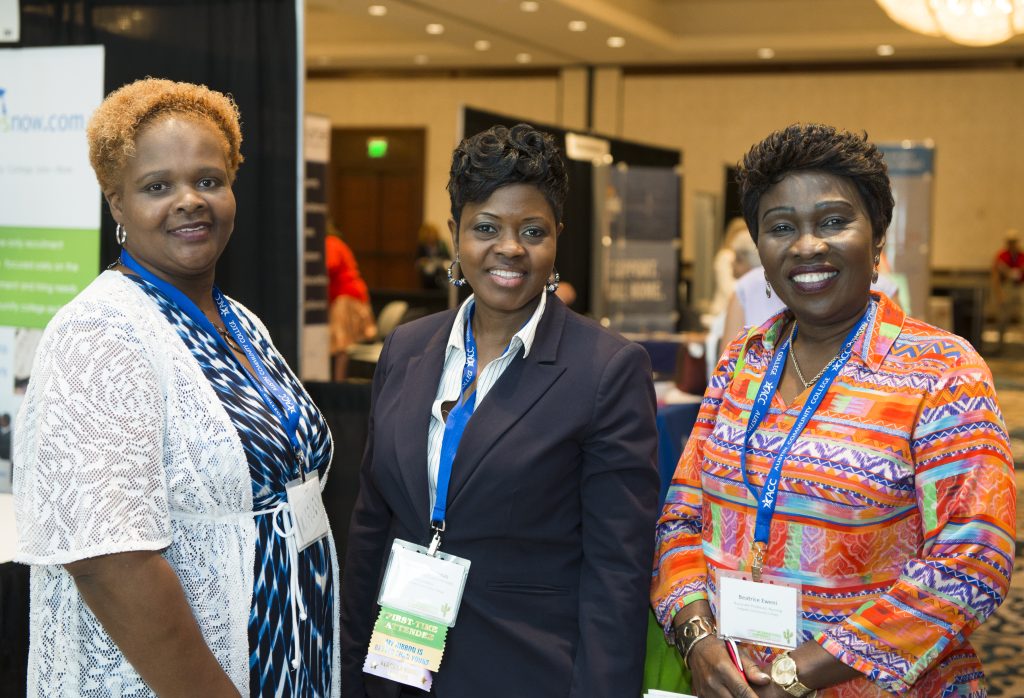 Three women visiting the exhibit area at NISOD's conference.