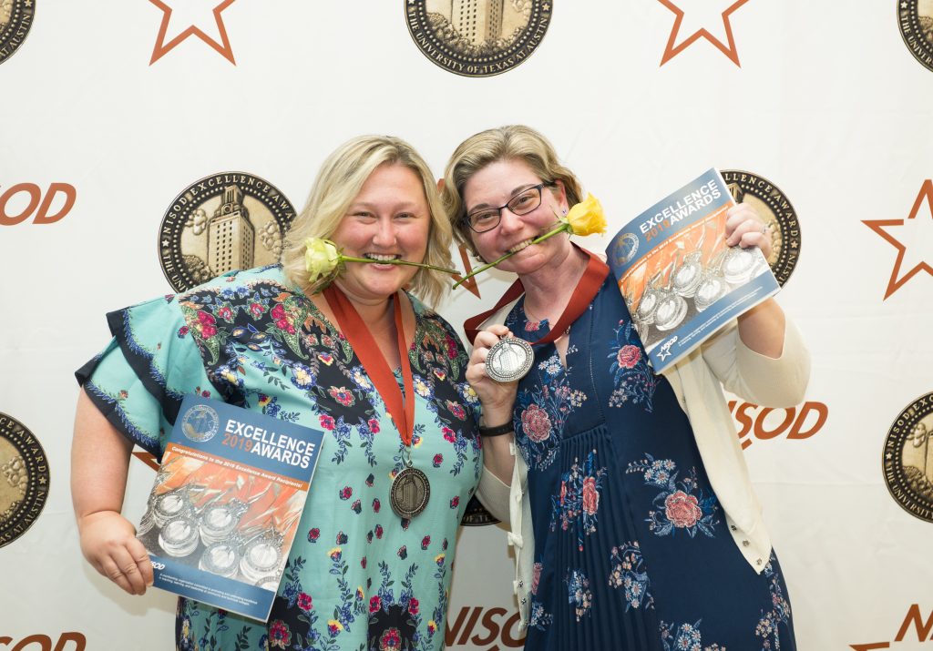 Two women pose with their excellence awards medallians